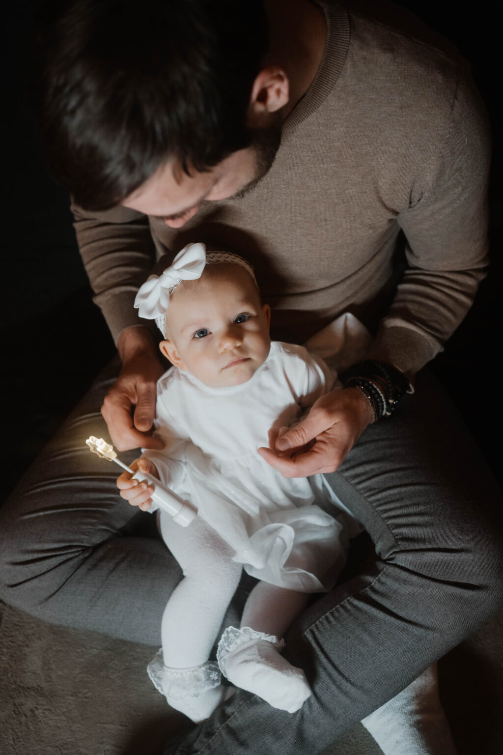Galerie Ein kleines Baby sitzt im Schoß vom Papa