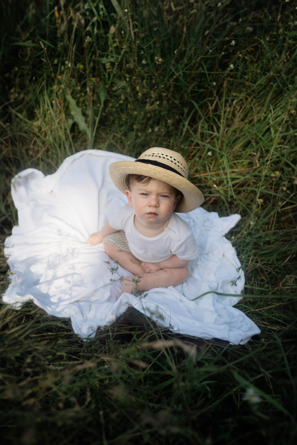 Galerie Ein kleiner Junge sitzt auf einer Decke im Gras Familienfotografie