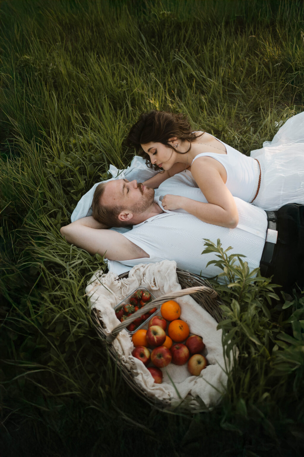 Galerie Ein Paar in der Natur liegend auf der Wiese mit einem Picknick bei Sonnenuntergang bei Paarfotografie Coupleshooting