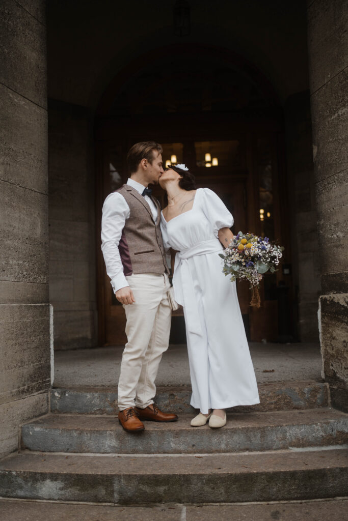 Paar küsst sich vor Standesamt Treptow Köpenick Hochzeitsfotografie in Berlin