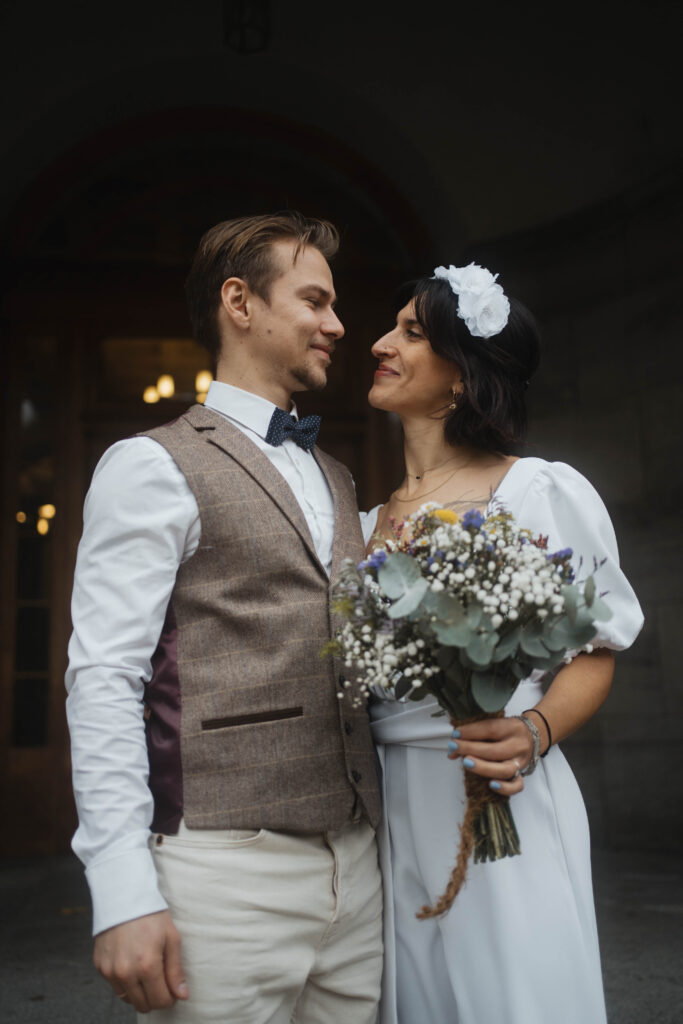 Frisch verheiratetes Hochzeitspaar mit Brautstrauß vor Standesamt Hochzeitsfotografie Berlin