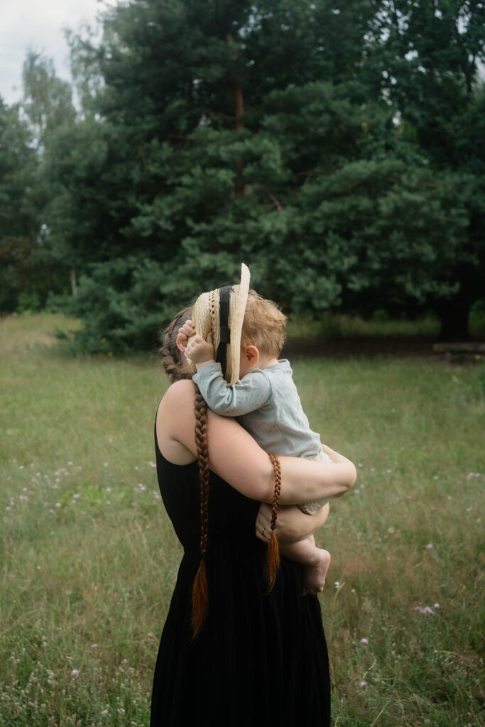 Mutter mit Sohn in der Natur auf dem Arm mit Strohhut Berlin