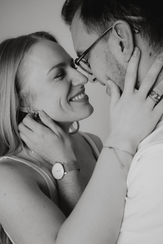 Verlobtes Paar lachen sich an und halten Gesichter Fotografie Hochzeitsfotografie in Berlin & Brandenburg