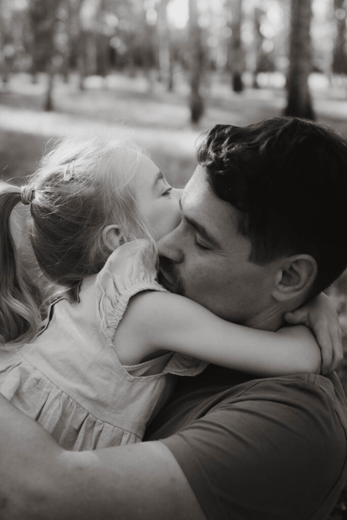 Vater und Tochter umarmen sich mit geschlossenen Augen Familienfotografie in Berlin & Brandenburg