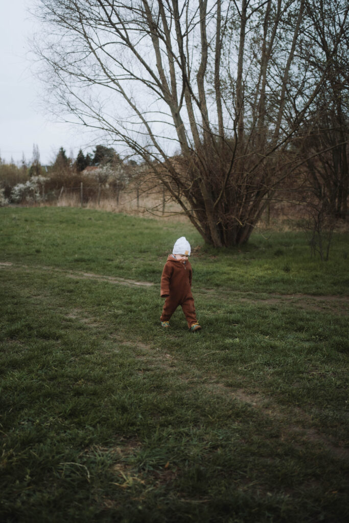 Kleiner Junge läuft draußen im Herbst