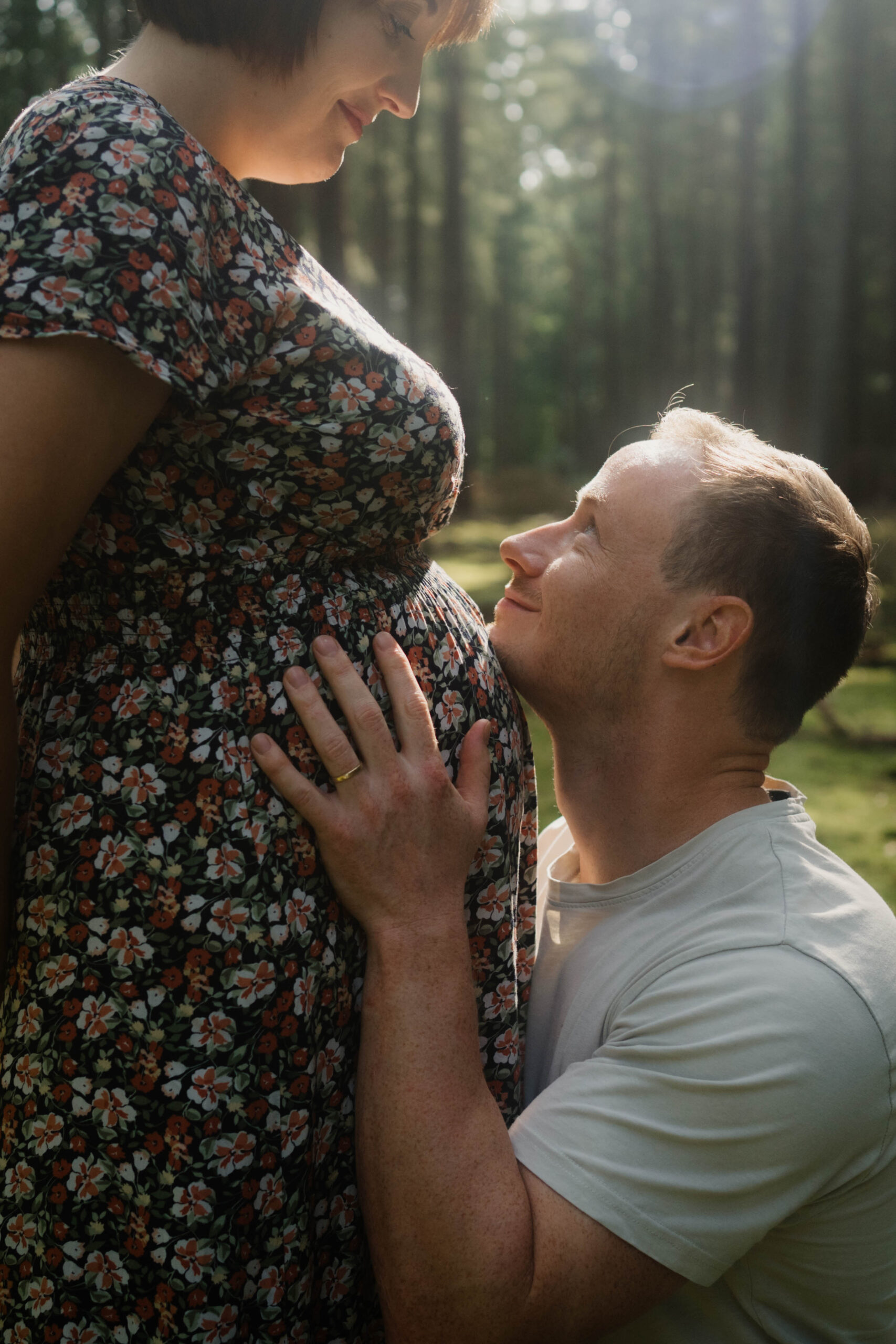 Schwangere Frau mit Babybauch bei einem Schwangerschaftsshooting im Freien