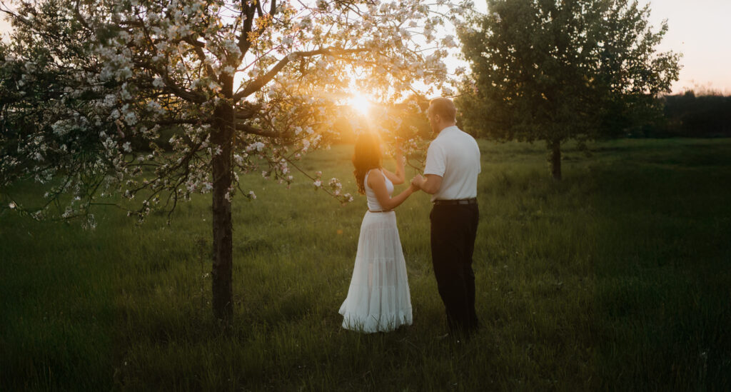 Ein Paar bei Sonnenuntergang in der Natur bei einem Kirschblütenbaum