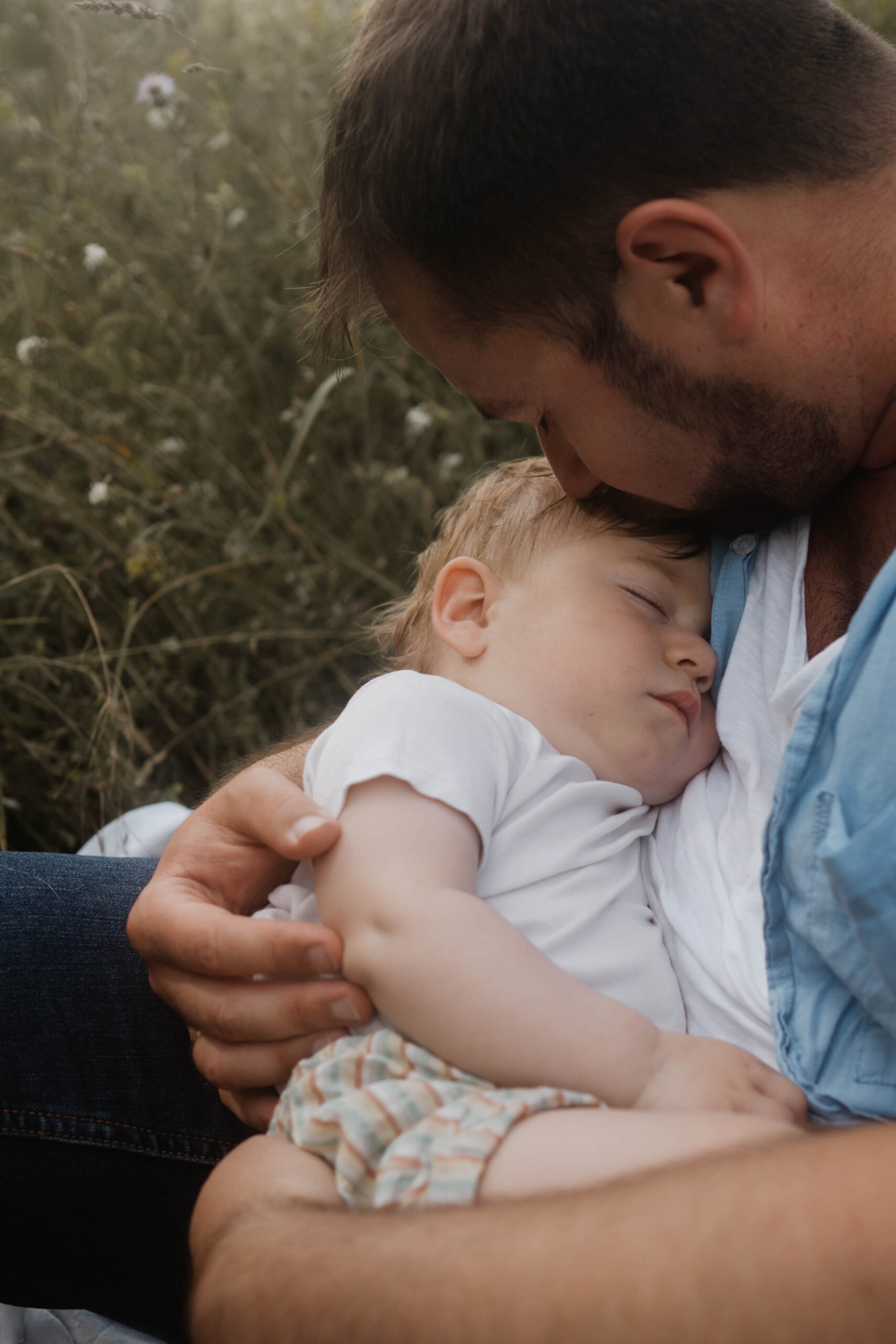 Kleines Baby schläft in Armen vom Vater