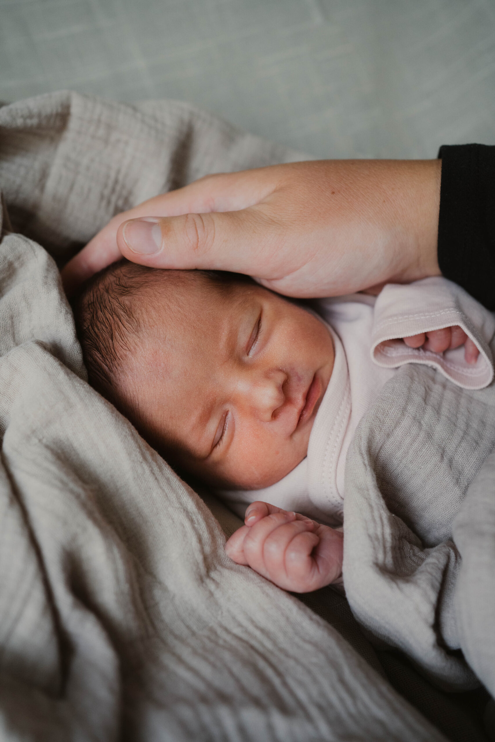 Neugeborenes und Hand von Mutter