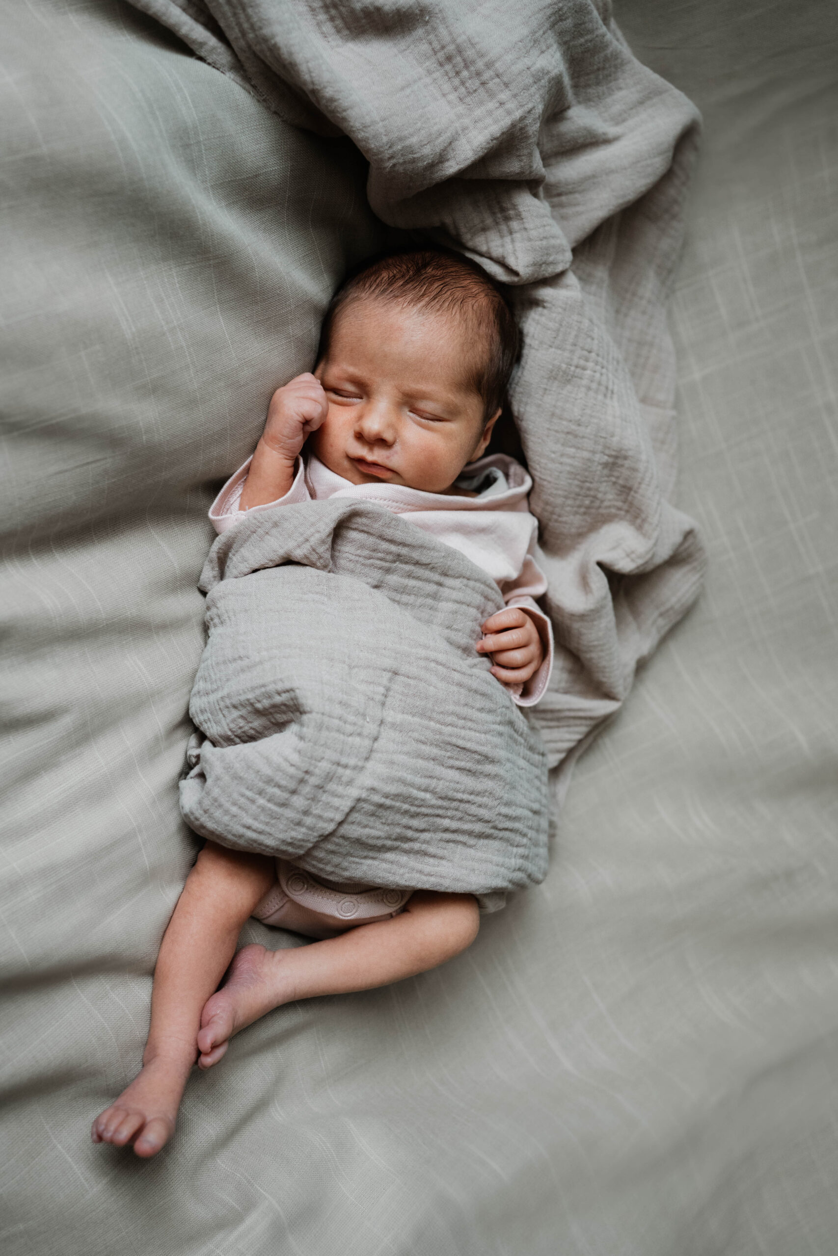 Neugeborenes Mädchen liegt auf Stofftüchern