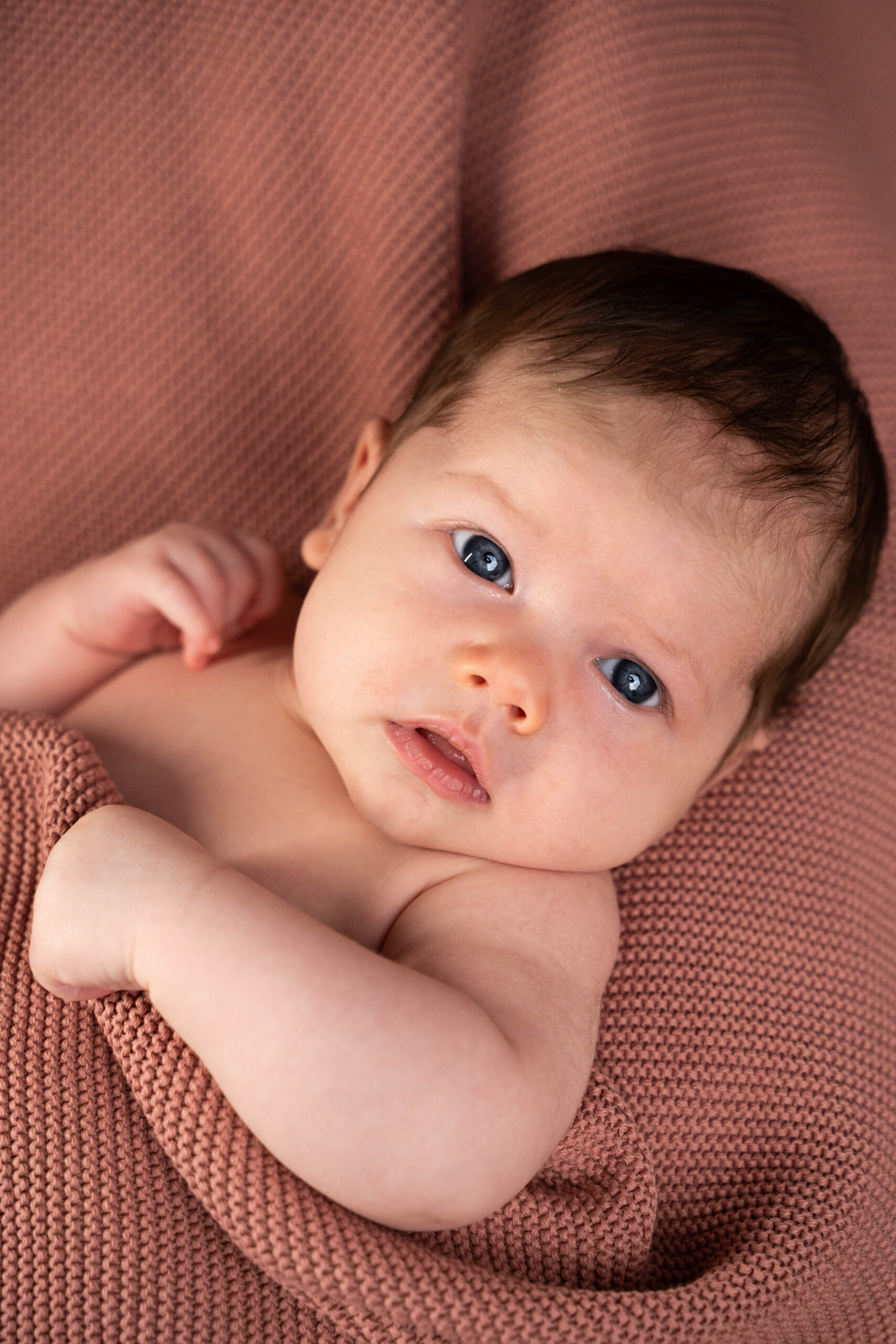 Neugeborenes Baby auf rosanem Häkeltuch