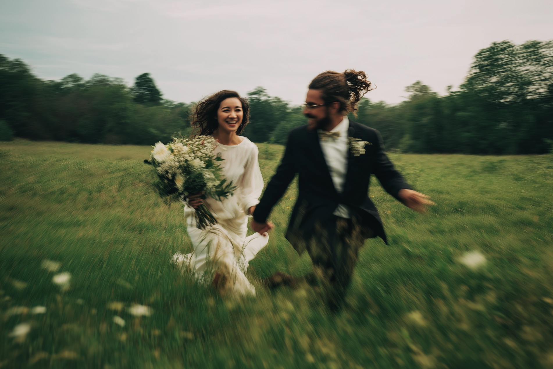 Paar nach Elopement rennt durch grüne Felder