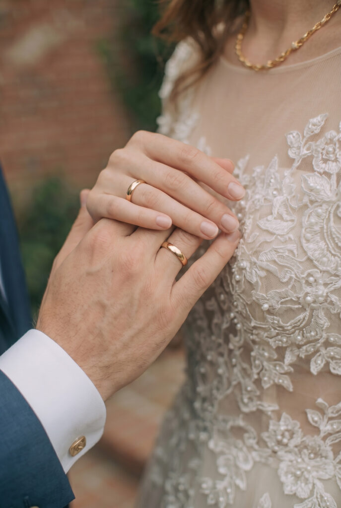 Braut und Bräutigam halten Hände und zeigen Eheringe