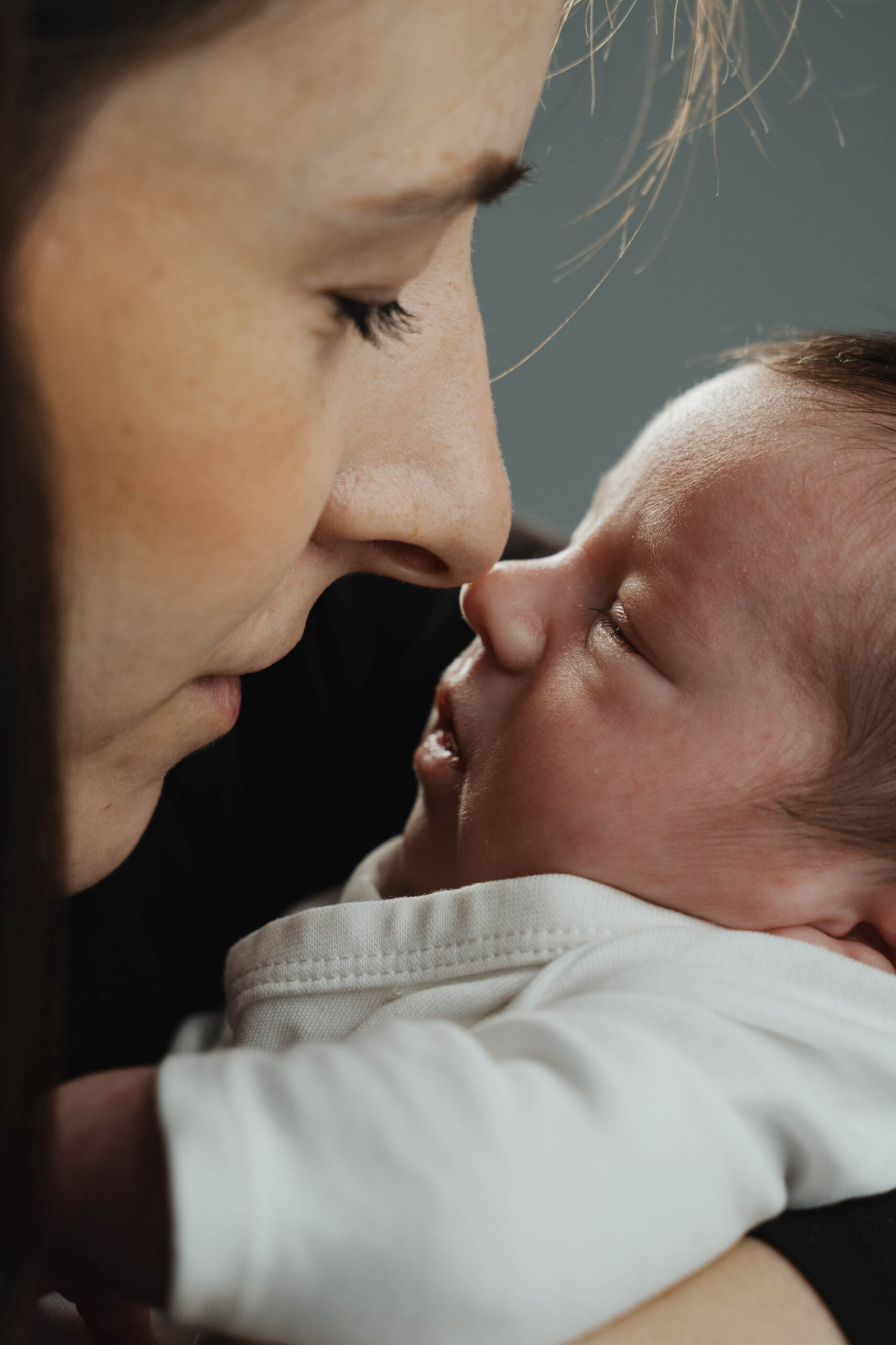 Mutter und neugeborenes Kind berühren sich mit den Nasen